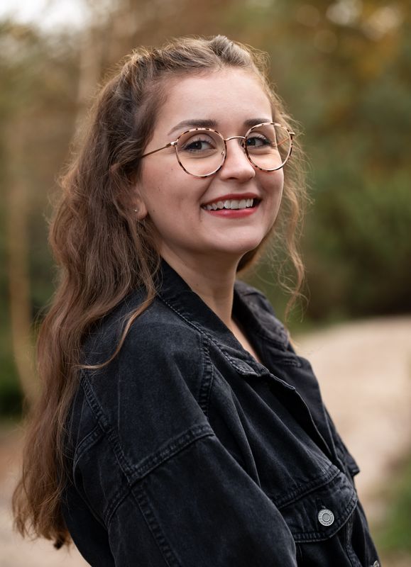 Lachende Frau mit Brille beim Outdoor-Shooting
